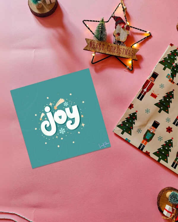 Joy Christmas card with bold retro typography and festive snowflakes on a teal background.