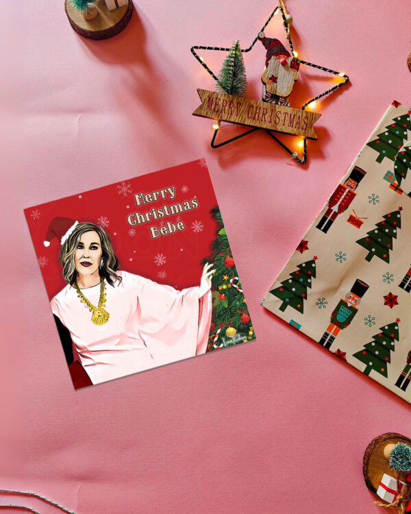 Schitt's Creek Moira Rose Christmas card featuring the quote 'Merry Christmas Bebe' with a holiday background.