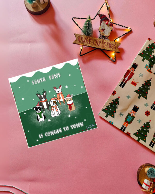 Christmas card featuring a lineup of dogs in festive costumes with the phrase 'Santa Paws is Coming to Town'.