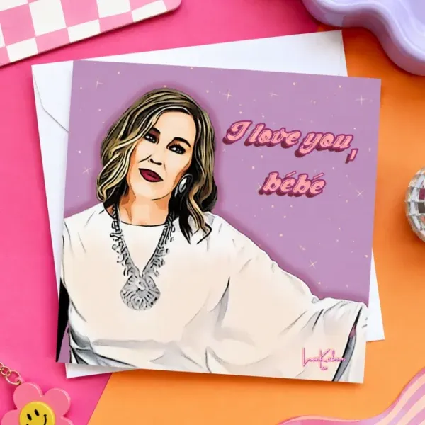 Moira Rose 'i Love You Bébé' Greeting Card flat lay on colourful table.