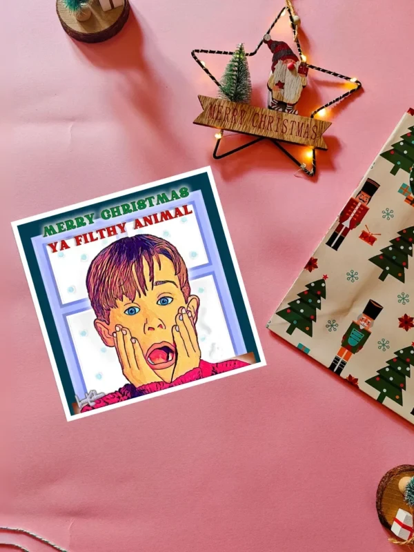 Home Alone Card Flatlay Merry Christmas Ya Filthy Animal illustrated Christmas card by Loon Kaboon
